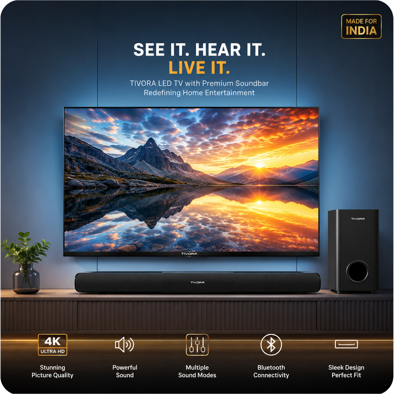 Tivola LED TV with a matching soundbar and a separate speaker, displayed on a wooden console against a dark blue wall. The TV screen shows a mountain landscape at sunset.